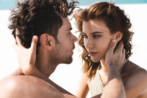 страстная сексуальная молодая пара смотрит друг на друга на пляже
 