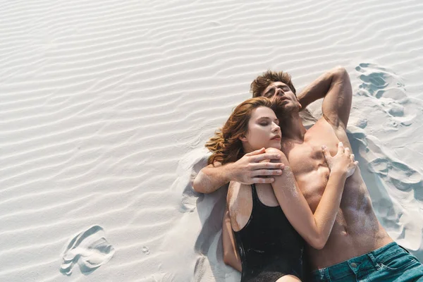 セクシー若いです男は砂のビーチでガールフレンドと横たわっています — ストック写真