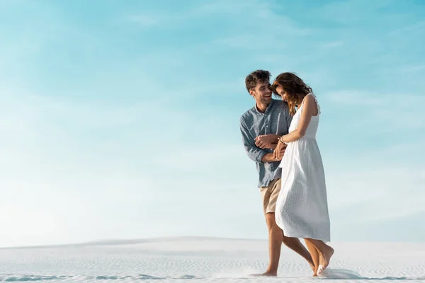 Sonriente Joven Pareja Caminando Playa Arena Contra Cielo Azul — Foto de Stock