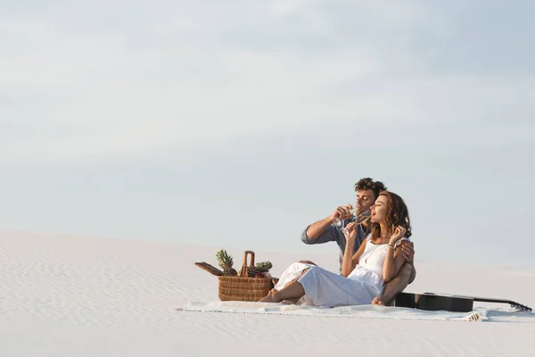 Young Couple Drinking Champagne While Sitting Blanket Basket Fruits Acoustic — Stock Photo, Image