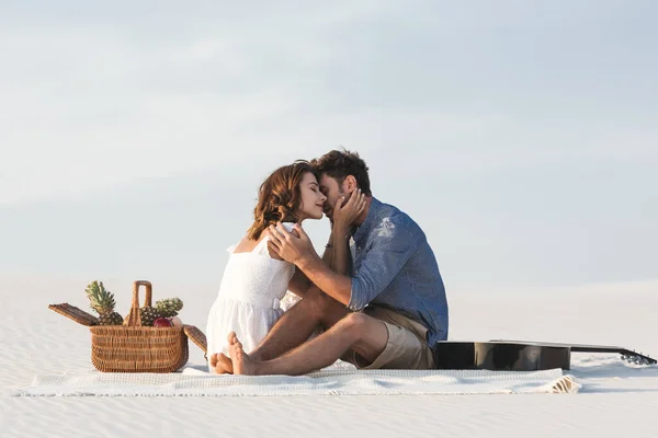 Junges Paar Umarmt Während Auf Einer Decke Mit Obstkorb Und — Stockfoto