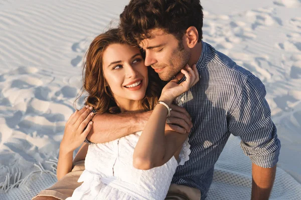 在海滩上拥抱的年轻夫妇笑着 — 图库照片