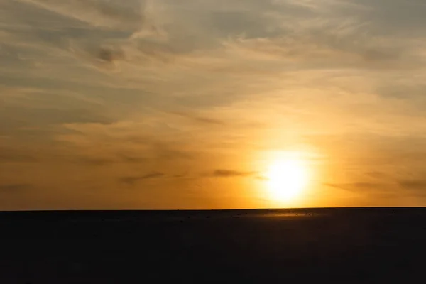 Темний Піщаний Пляж Проти Яскравого Сонця Під Час Заходу Сонця — стокове фото