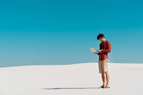 Jovem Freelancer Praia Areia Com Laptop Contra Céu Azul Claro — Fotografia de Stock