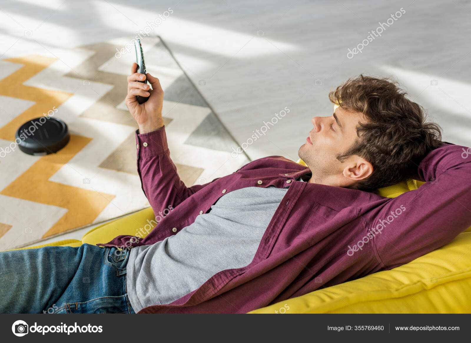 Overhead View Man Relaxing Sofa Watching Movie While Robotic Vacuum