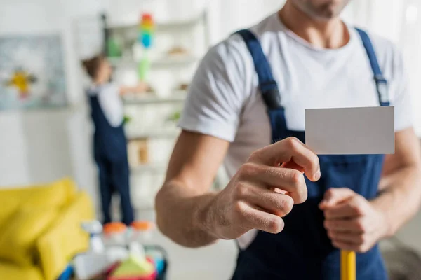 Vista Recortada Del Limpiador Uniforme Con Tarjeta Blanco Apartamento — Foto de Stock