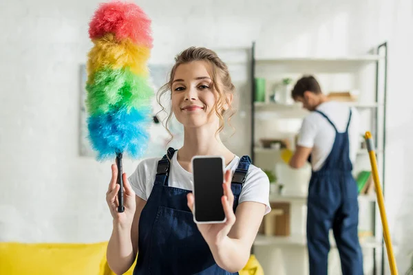 Selective Focus Happy Attractive Cleaner Holding Smartphone Blank Screen Duster — Stock Photo, Image