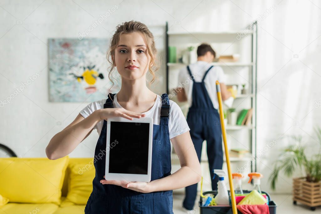 selective focus of happy and attractive cleaner holding digital tablet with blank screen 