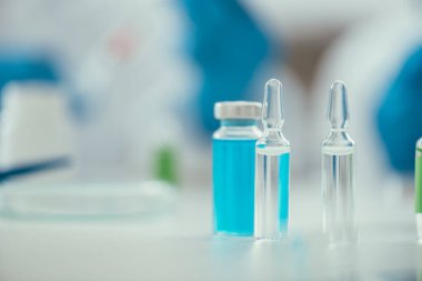 İlaçlı cam kapların yanındaki ampullerin seçici odak noktası, covid-19 konsepti