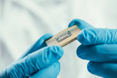 Bilgisayar mikroçipi tutan lastik eldivenli mühendis görüntüsü