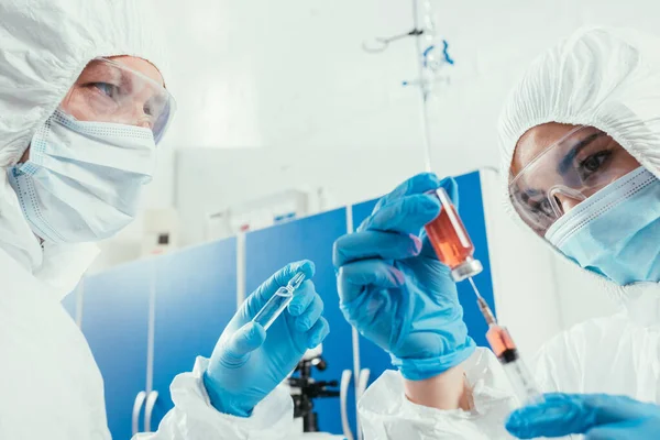 Bioquímico Tomando Medicamentos Con Jeringa Mientras Colega Sostiene Ampollas — Foto de Stock