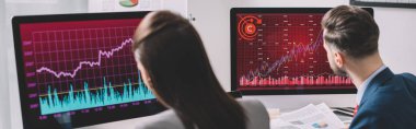 Ofisteki bilgisayar monitörleri ve panoramik çekim üzerinde çalışan veri analistlerinin seçici odak noktası