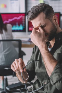 Ofiste gözlük tutan yorgun bilgi güvenlik analistinin seçici odak noktası 