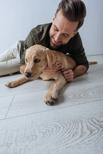 Low Angle View Smiling Man Petting Golden Retriever Floor Grey — Stock Photo, Image