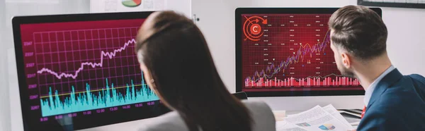 オフィスのコンピュータモニタ上のグラフを扱うデータアナリストの選択的な焦点 パノラマショット — ストック写真