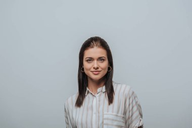 Gri renkli kameraya gülümseyen çekici kadın.