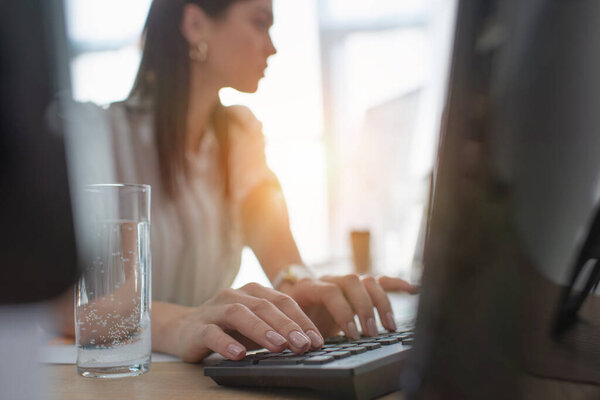 Selective focus of data analyst typing on computer keyboard in office 