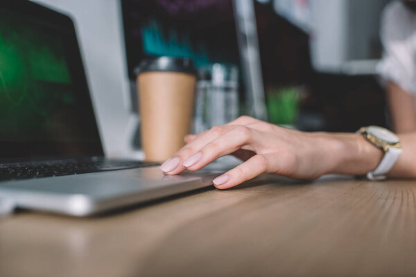 Cropped view of data analyst using laptop at table in office 