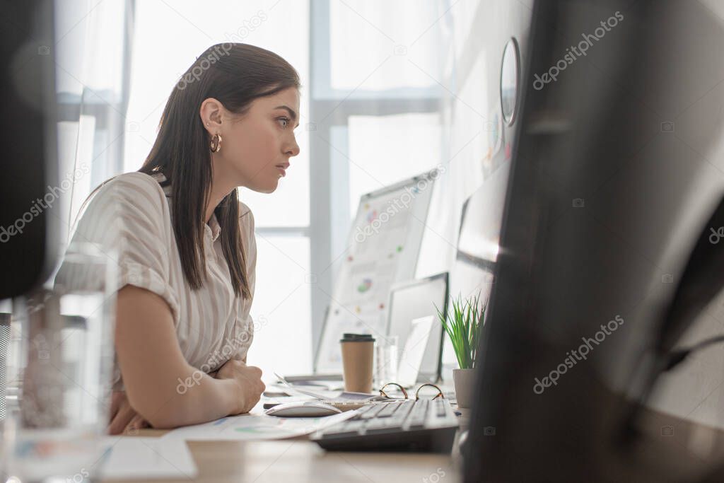 Selective focus of information security analyst working with computers in office 