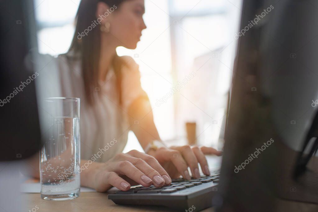 Selective focus of data analyst typing on computer keyboard in office 