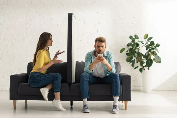 Confused Girl Looking Big Model Smartphone Addicted Boyfriend Chatting Sofa — Stock Photo, Image