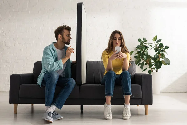 Homem Sentado Perto Modelo Smartphone Namorada Viciada Conversando Sofá — Fotografia de Stock