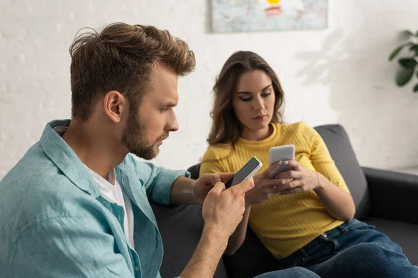 Enfoque Selectivo Pareja Adicta Utilizando Teléfonos Inteligentes Sofá —  Fotos de Stock