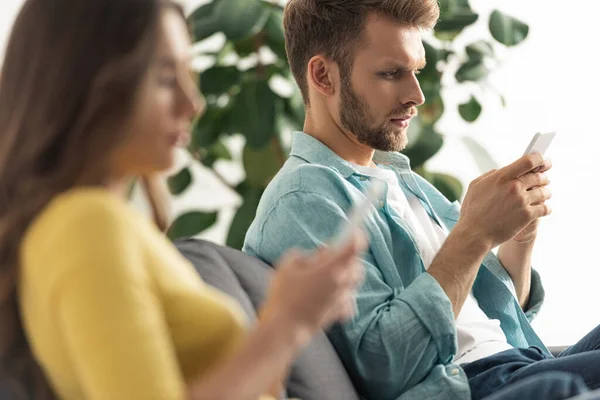 Foco Seletivo Homem Usando Smartphone Perto Namorada Conversando Sofá — Fotografia de Stock