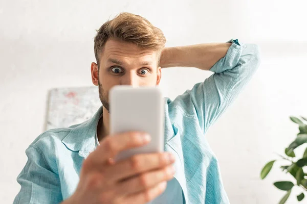 Selektivt Fokus Chockad Man Med Hjälp Smartphone Vardagsrummet — Stockfoto
