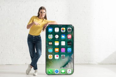 KYIV, UKRAINE - 21 Şubat 2020: iPhone ekranlı akıllı telefon modelini gösteren gülümseyen kız 