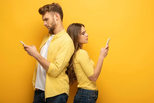 Side View Young Depended Couple Using Smartphones Yellow Background — Stock Photo, Image