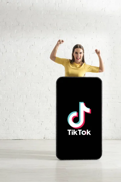 Kyiv Ukraine 2020年2月21日 Tiktokアプリでスマートフォンのモデルに近い位置に立っている間 ええジェスチャーを示す陽気な女の子 — ストック写真