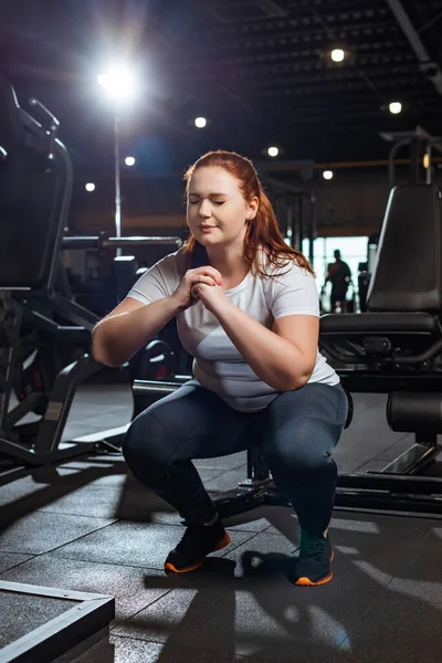 Concentrated Overweight Girl Closed Eyes Squatting Clenched Hands Gym — Stock Photo, Image