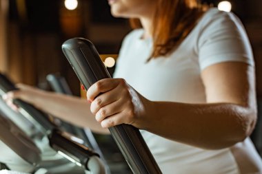Kilolu bir kızın spor salonunda stepper üzerinde çalışmasını izledik.