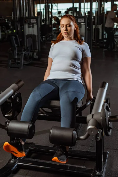 Centrado Chica Con Sobrepeso Haciendo Ejercicio Extensión Pierna Máquina Entrenamiento — Foto de Stock