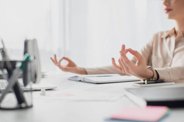 İş yerinde Gyan Mudra 'yla meditasyon yapan iş kadınının not defteriyle görüntüsü. 