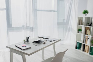 Modern ofisteki iş yeri hakkında dizüstü bilgisayar ve belgeler