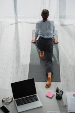 İş kadınının yoga yaptığı ve ofiste bacaklarını açtığı arka plan görüntüsü 