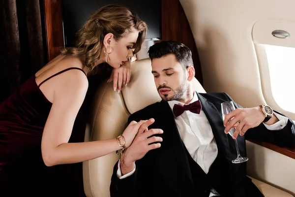 Verführerische Frau Berührt Eleganten Mann Mit Glas Champagner Flugzeug — Stockfoto