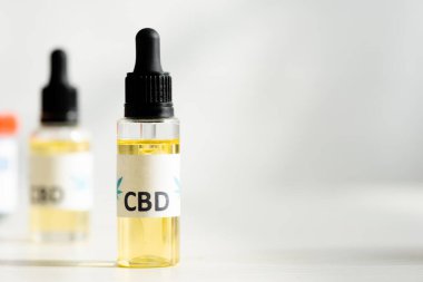 selective focus of bottle with oil and cbd lettering on table  clipart