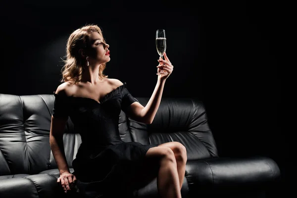 Elegantní Dívka Černých Šatech Drží Sklo Šampaňského Zatímco Sedí Kožené — Stock fotografie