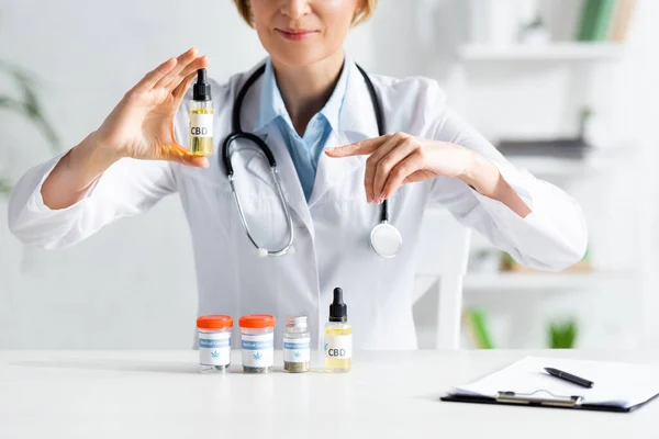 Cropped View Doctor White Coat Pointing Finger Bottle Cbd Lettering — Stock Photo, Image