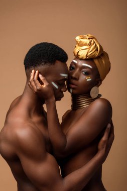Bej rengi üzerinde yalnız poz veren seksi, çıplak afro bir çift.