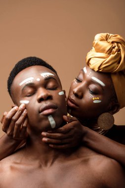 Bej rengi yüzleri boyalı çıplak kabile afro çifti.