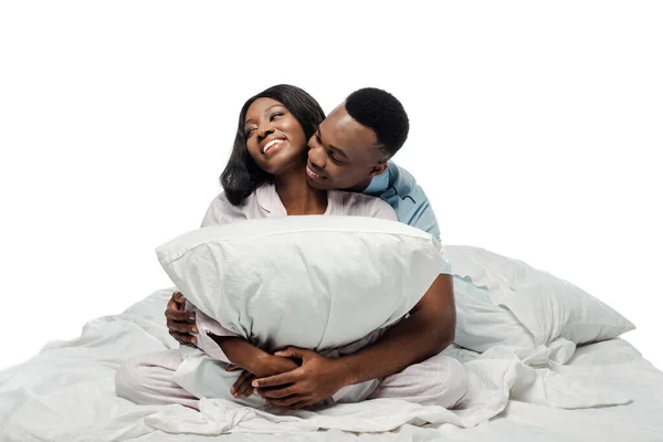 Feliz Casal Afro Americano Abraçando Travesseiro Cama Pijama Isolado Branco — Fotografia de Stock