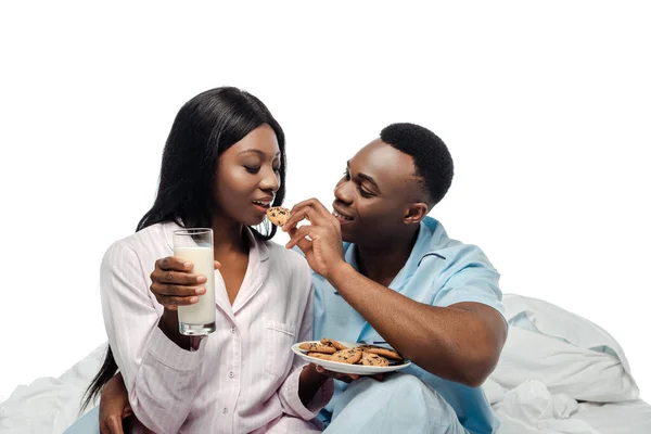 Happy African American Man Feeding Girlfriend Cookies Bed Pajamas Isolated — Stock Photo, Image