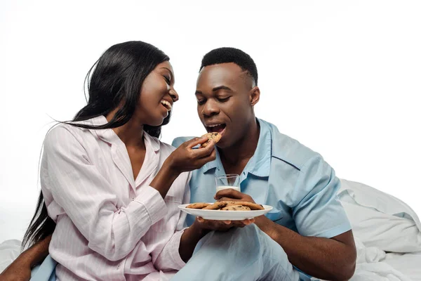 Happy African American Woman Feeding Boyfriend Cookies Bed Pajamas Isolated — Stock Photo, Image