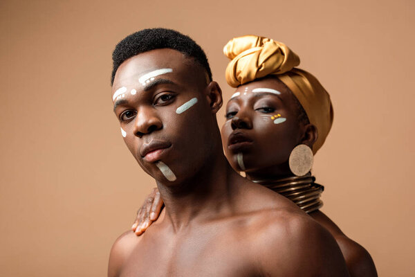 сексуальная обнаженная племенная афро-пара позирует на бежевом
