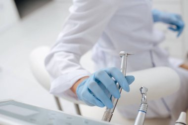 Paslanmaz diş aletini alan dişçi görüntüsü 