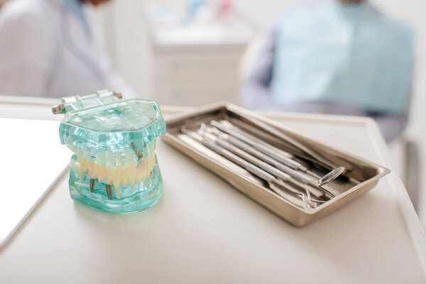 selective focus of dental instruments near teeth model in clinic 